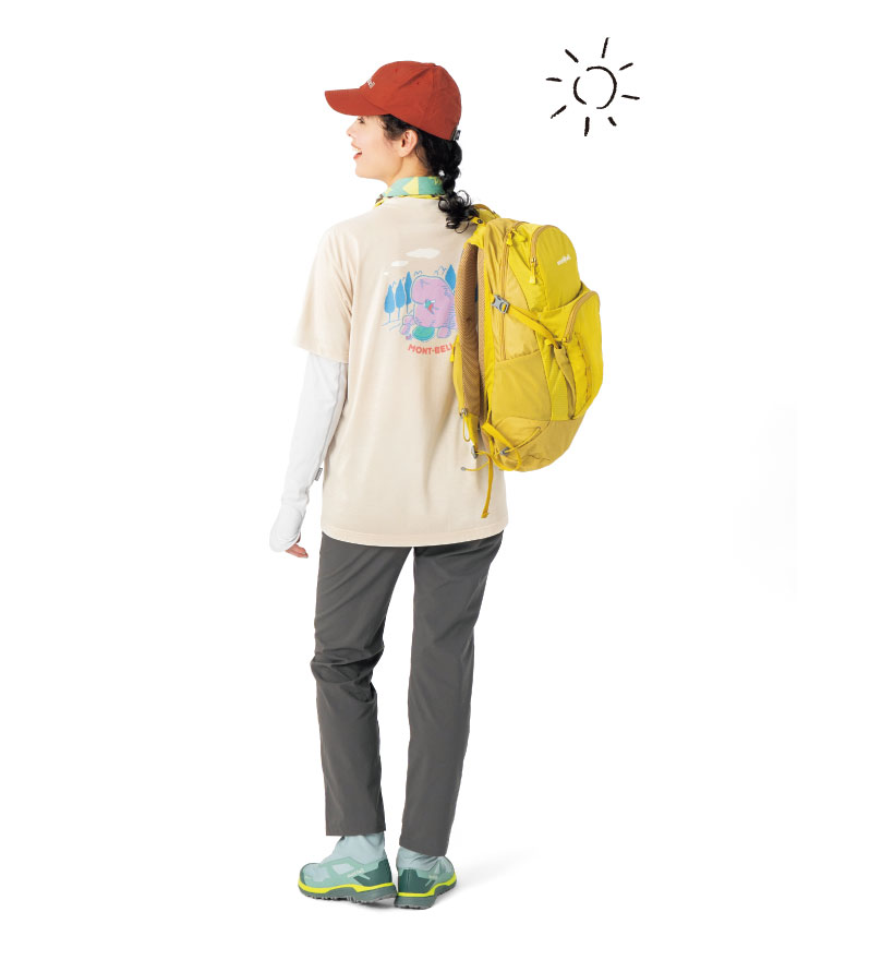 ベージュ色のTシャツに白いアームカバー、濃いグレーの長ズボンを履いた女性モデル。ワインレッドのキャップをかぶり、黄色いリュックを背負っている